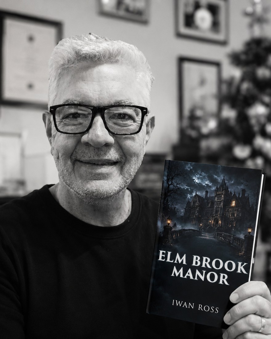 Iwan Ross, founder of BlurbCraft Studio, holding his novel Elm Brook Manor